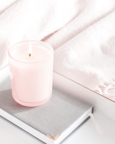 candle on book on tray on bed