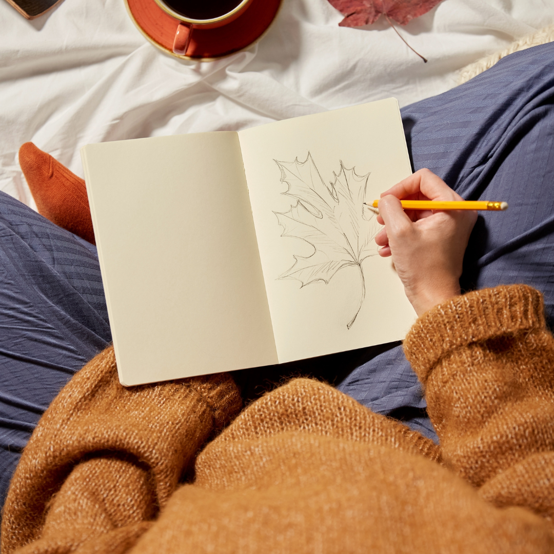 Woman enjoying a peaceful moment and drawing during autumn.